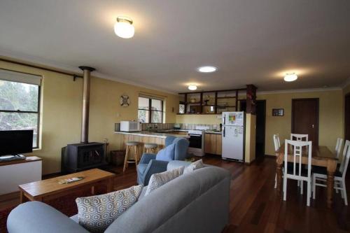 a living room with a couch and a table and a kitchen at Jen’s Beach House - easy walk to the Ocean, Colourpatch Cafe by the river in Augusta