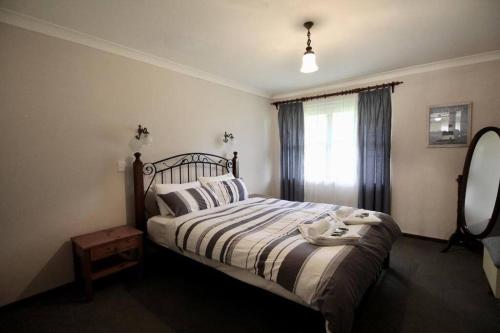 a bedroom with a bed and a window at Jen’s Beach House - easy walk to the Ocean, Colourpatch Cafe by the river in Augusta