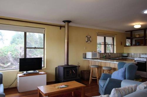 a living room with a kitchen and a stove at Jen’s Beach House - easy walk to the Ocean, Colourpatch Cafe by the river in Augusta