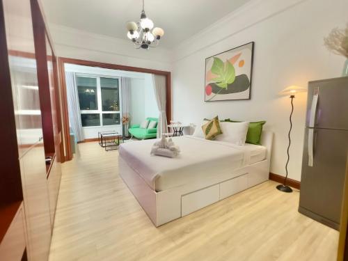 a bedroom with a white bed and a living room at Diny ApartHotel - Rooftop Pool - The Manor 2 in Ho Chi Minh City
