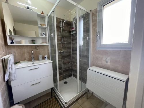 une salle de bain avec douche et lavabo dans l'établissement Royan : T2 cosy avec terrasse, proche plage et commerces, parking privé - FR-1-71-63, à Royan
