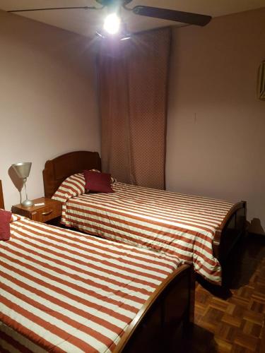 a bedroom with two beds and a light on the ceiling at DEPTO CENTRICO Y ACOGEDOR in San Miguel de Tucumán