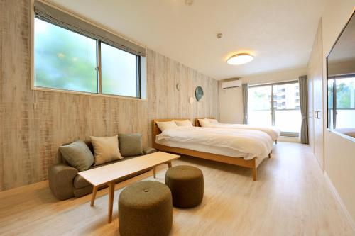 a bedroom with a bed and a couch and a chair at Rakuten STAY x Shamaison Osaka Dekijima Station in Osaka