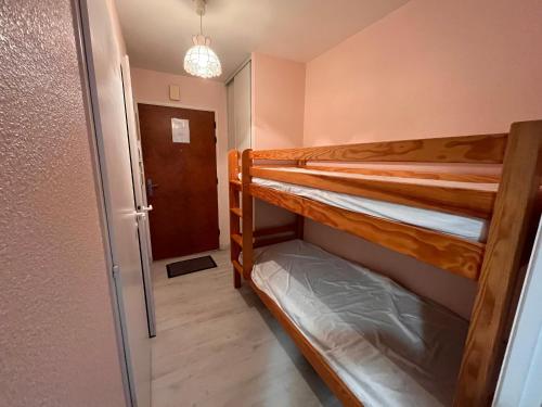 Ce dortoir comprend 2 lits superposés et une porte. dans l'établissement Studio avec Piscine, Parking et Balcon aux Sables-d'Olonne - FR-1-197-380, à Les Sables-dʼOlonne
