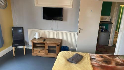 um quarto com uma cama, uma mesa e uma televisão em The Fox em Bristol