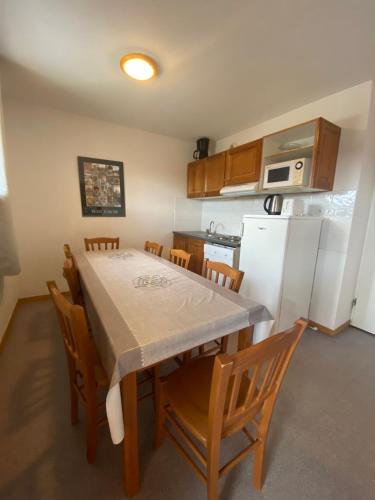 une cuisine avec une table, des chaises et un réfrigérateur dans l'établissement Apartment at the foot of the slopes, à Saint-Étienne-en-Dévoluy