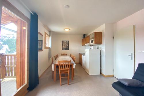 une petite cuisine avec une table et un réfrigérateur dans l'établissement Apartment at the foot of the slopes, à Saint-Étienne-en-Dévoluy