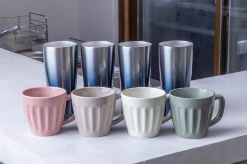 a group of cups and saucers on a counter at HIDA TAKAYAMA BASE - Traditional Japanese Garage House with Private Sauna in Takayama