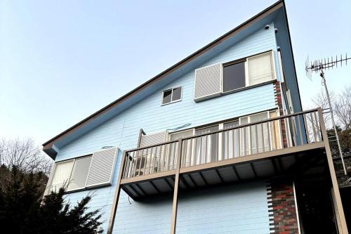 a blue house with a balcony on the side of it at 熱海 フィレンツェ in Atami