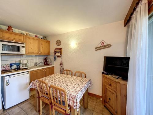 une cuisine avec une table, des chaises et une table, ainsi qu'une télévision dans l'établissement Studio cabine proche centre Combloux, 4 pers, balcon, parking - FR-1-560-53, à Combloux