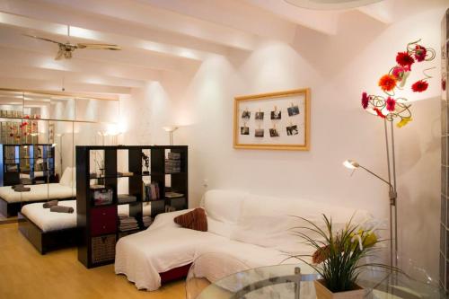 Studio Gracia By MyRentalHost في برشلونة: غرفة معيشة مع أريكة بيضاء وطاولة زجاجية