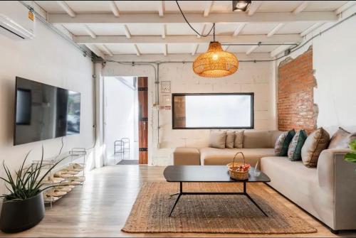 a living room with a couch and a table at 3BR House in Thapae l NightBazaar in Chiang Mai