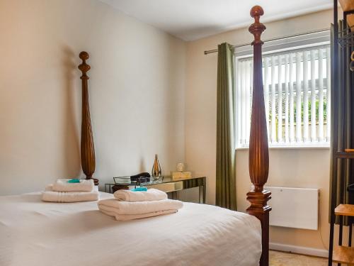 1 dormitorio con 2 camas con sábanas blancas y ventana en Castaway 14-uk45097, en Kessingland