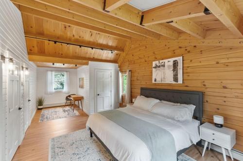 a bedroom with a bed and a wooden wall at Our Pondside Cabin in Westminster