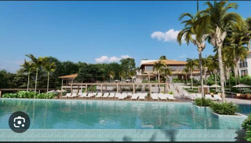 a pool at a resort with chairs and palm trees at Quinta Santa Bárbara eco resort in Pirenópolis
