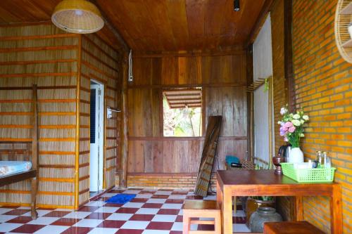 Habitación con mesa y suelo a cuadros en Farmstay Sokfarm, en Trà Vinh