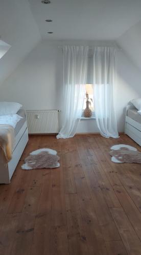 a bedroom with a bed and a window with rugs at Stilvolle Ferienwohnung free parking, Space, WLAN in Niestetal