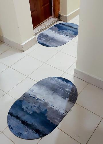 two blue mats on the floor in front of a door at Airbnb in Ruiru