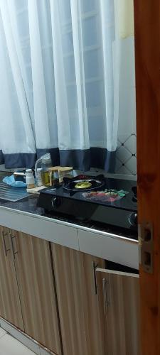 a kitchen counter with a stove with dishes on it at Airbnb in Ruiru