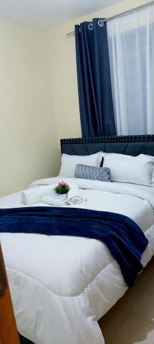 un grande letto bianco con una tastiera di Airbnb a Ruiru
