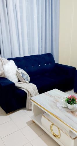 a living room with a blue couch and a table at Airbnb in Ruiru