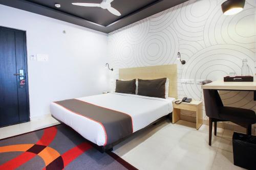 um quarto com uma cama e uma secretária. em Townhouse Halcyon Hi-Tech City Near Medicover Hospital em Kondapur