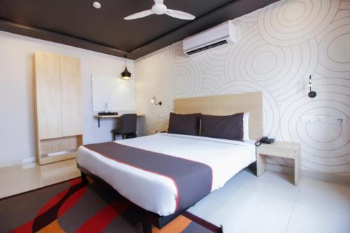 sypialnia z dużym łóżkiem i ścianą w obiekcie Townhouse Halcyon Hi-Tech City Near Medicover Hospital w mieście Kondapur