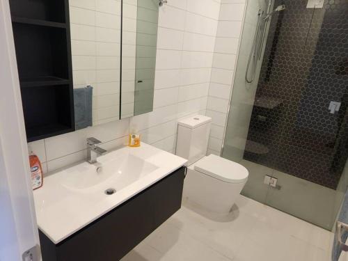 a bathroom with a toilet and a sink and a shower at Modern Apartment Airport Area in Melbourne