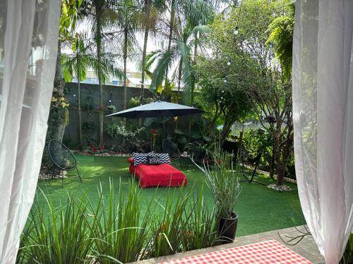 a garden with a table and an umbrella at UFSC Guest House in Florianópolis