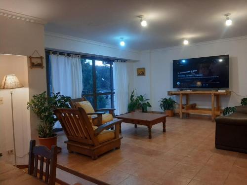 ein Wohnzimmer mit einem großen Flachbild-TV in der Unterkunft TZION B&B in Ushuaia