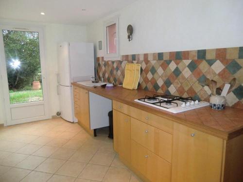 cocina con encimera, fogones y nevera en La voliere, en Toulon
