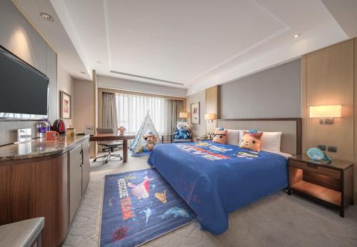 a hotel room with a bed and a flat screen tv at Shangri-La Changchun in Changchun