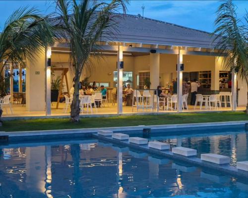 a house with a swimming pool and a restaurant at Escapada frente al mar, Piscinas y los Mejores Atardeceres -Playa Caracol- in El Quindio