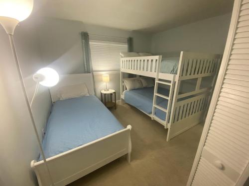 a small room with two bunk beds and a lamp at Seaside Sanctuary Condo Villa - Private Beach Access, 3 Pools in Hilton Head Island