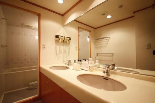 a bathroom with two sinks and a large mirror at Wakamatsu Honten in Narita