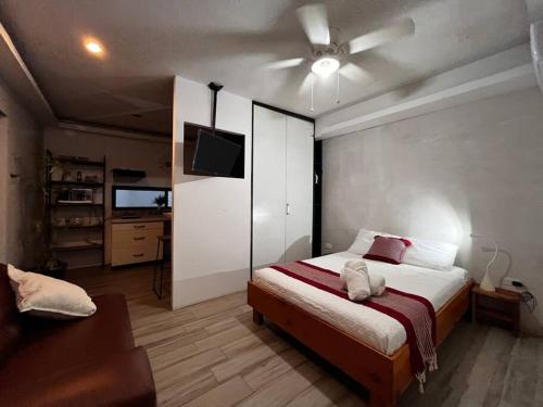 a bedroom with a bed and a ceiling fan at Garden Suite 1 Estación 48 in Mérida