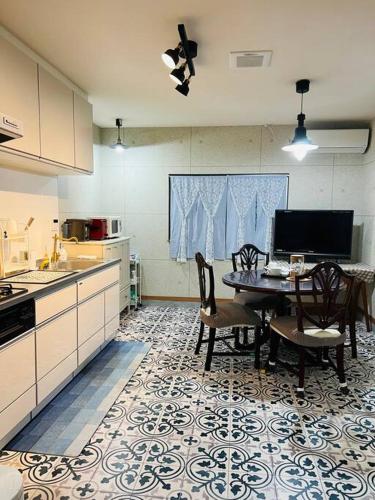 a kitchen with a table and chairs in a kitchen at 鹤桥站3线热门大站独栋别墅3卧室双卫心斋桥日本桥2站道顿堀3站难波3站梅田Usj神户京都奈良一线直达 in Osaka