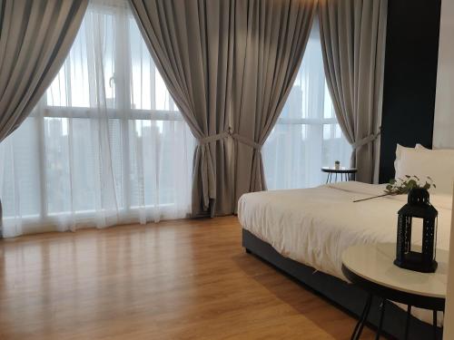 a bedroom with a bed and large windows at Quill Residence KLCC By Ezhome in Kuala Lumpur