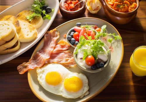 a table with two plates of eggs and bacon and bread at Four Points by Sheraton Shanghai, Daning in Shanghai