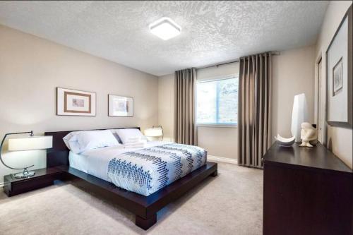 a bedroom with a large bed and a window at Monthly Furnished Bright Beautiful 3bedroom Suite in Victoria