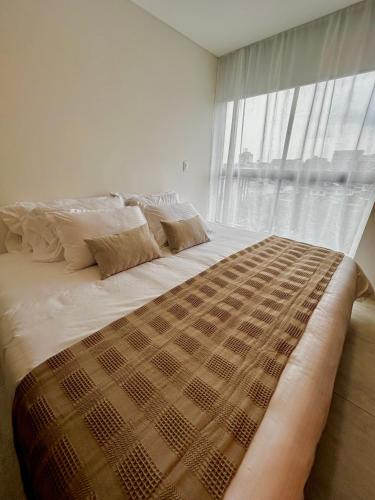a bedroom with a large bed with a large window at INTO suites, suite de lujo in Armenia