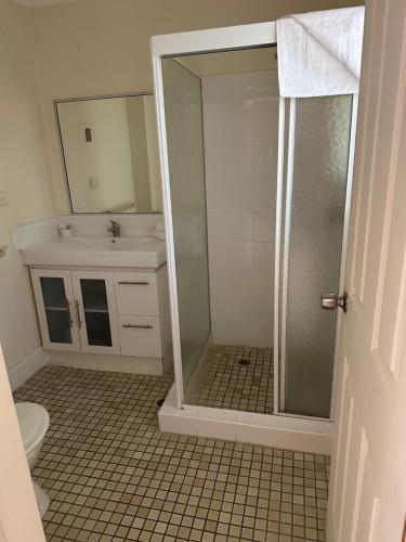 a bathroom with a shower and a toilet and a sink at Gold Coast Airport Motel - Only 300 Meters To Airport Terminal in Gold Coast