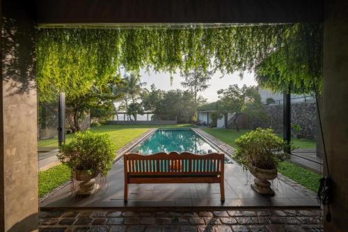 a porch with a bench and a swimming pool at Tranquil Waters in Negombo