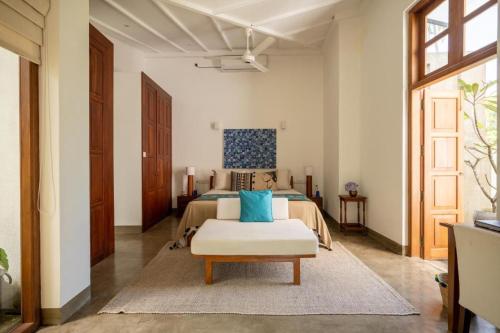 een slaapkamer met een bed met blauwe kussens erop bij Tranquil Waters in Negombo