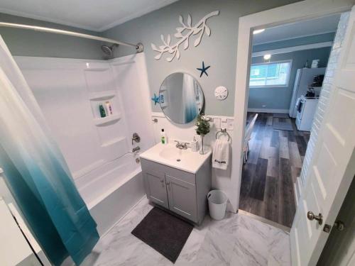 La salle de bains est pourvue d'un lavabo, d'une douche et d'un miroir. dans l'établissement The Cottage At Long Lake, à Portage