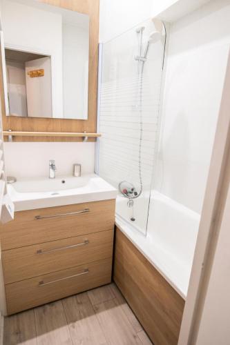 une salle de bain avec un lavabo blanc et une douche dans l'établissement Résidence Les Campanules - LES CAMPANULES - CA11FC MAE-3147, à Villarodin-Bourget
