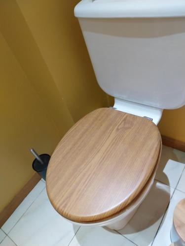 La salle de bains est pourvue de toilettes et d'un siège en bois. dans l'établissement T2 confort, à Théza