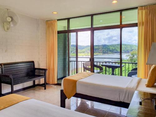 a hotel room with two beds and a balcony at Phornpailin Riverside Resort in Sangkhla Buri