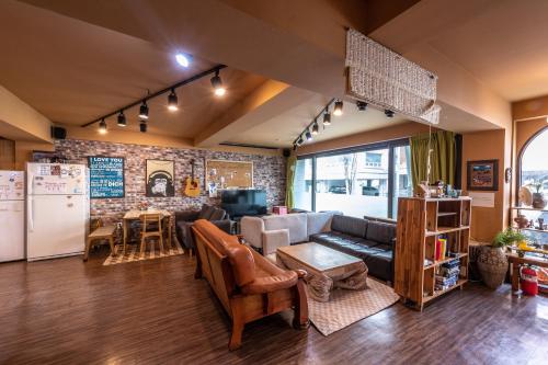 a living room with a couch and a kitchen at UWA Guesthouse in Seoul