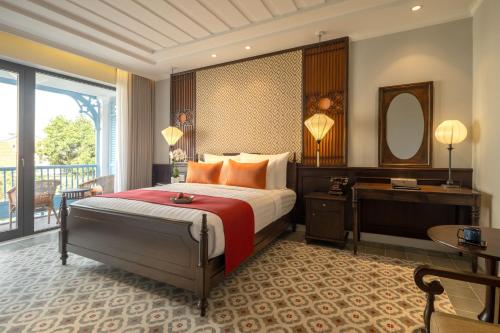 Habitación de hotel con cama y espejo en Little Residence- A Boutique Hotel & Spa en Hoi An